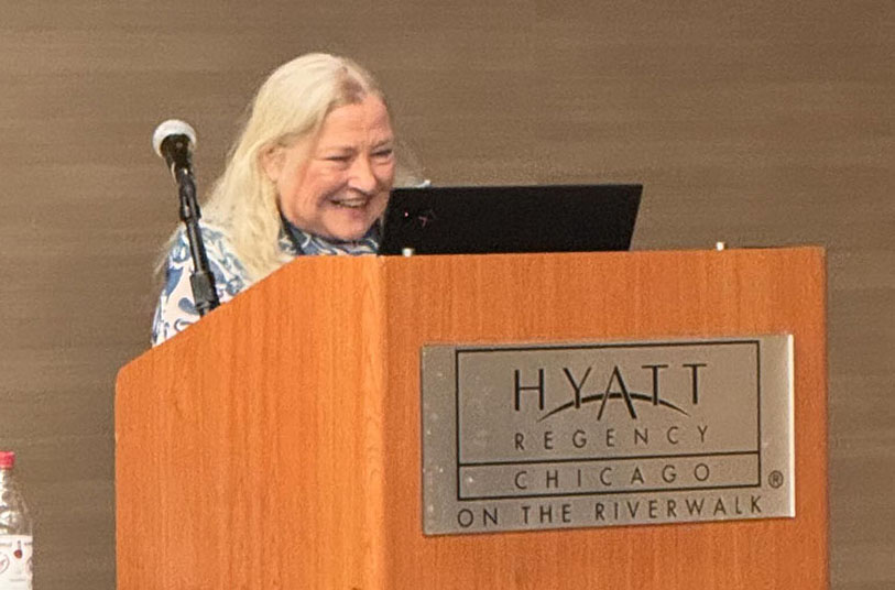 A woman stands behind a lectern.